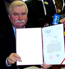 Lech Wałęsa prezentuje dokumenty IPN potwierdzające status pokrzywdzonego. To prezent od Leona Kieresa.