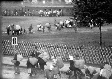Polacy pod eskortą funkcjonariuszy policji w drodze do pociągu (data i miejscowość nieustalona). (fot. Józef Macikowski; w zbiorach elektronicznych OKŚZpNP w Katowicach).